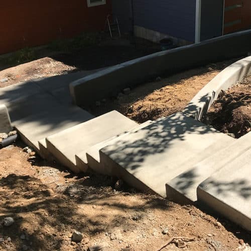 Brushed concrete steps going down to a home entrance