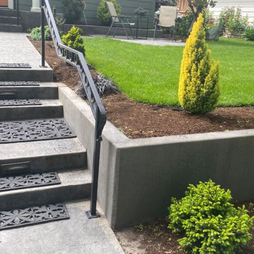 Concrete retaining wall elevates this already clean, modern front yard