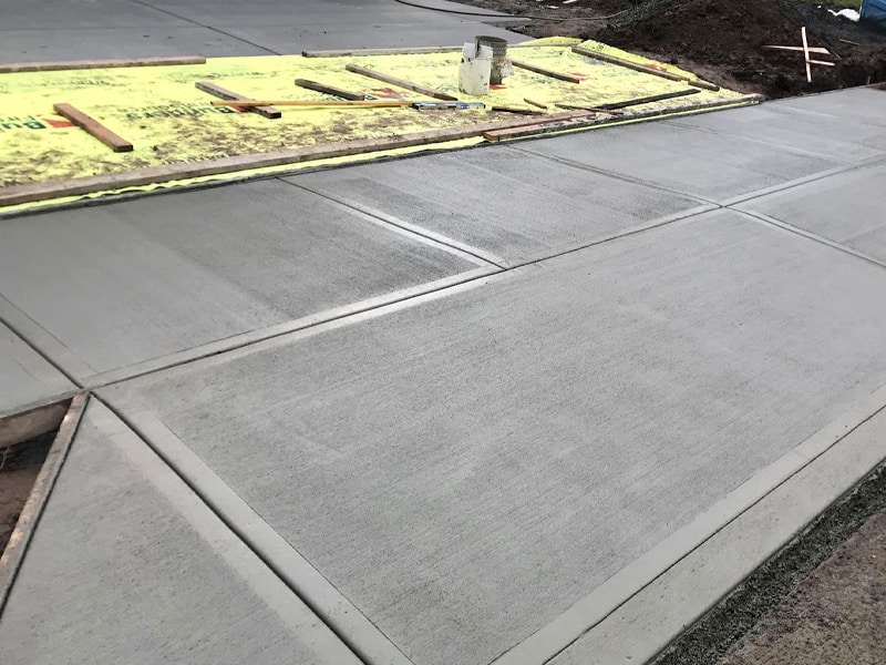 Concrete walkway out front of a driveway