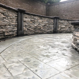 Stamped concrete patio with a hardscape fire pit at the center
