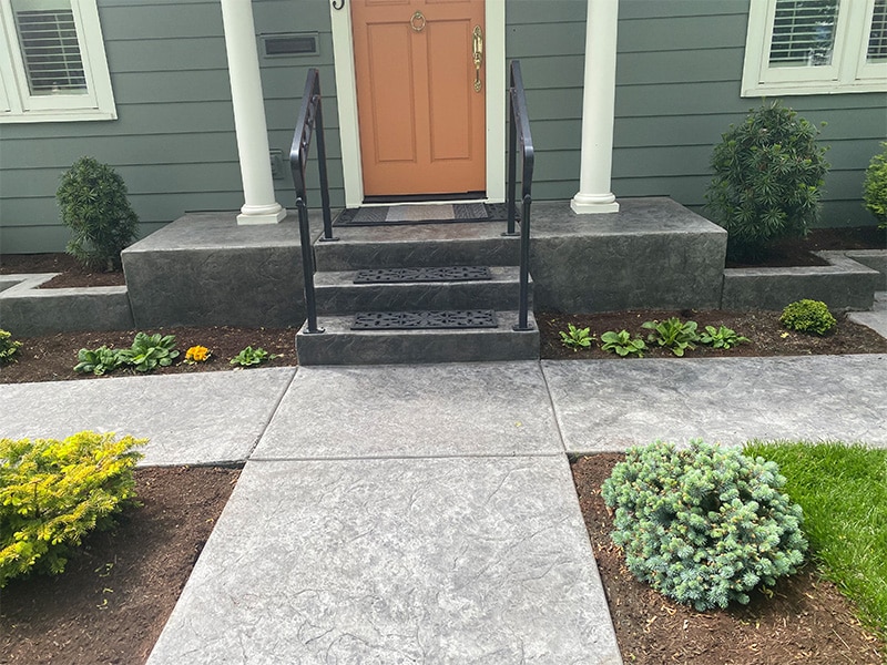 Stamped concrete walkway leads to steps and home entrance