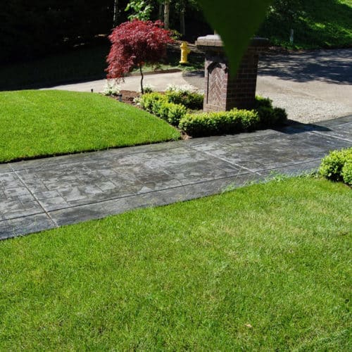 Stamped concrete walkway surrounded by grass