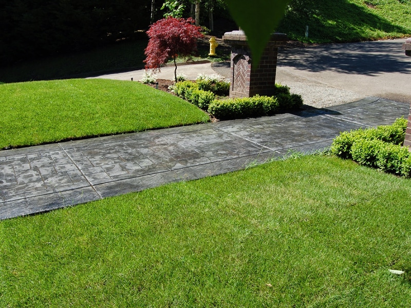 Stamped concrete walkway surrounded by grass