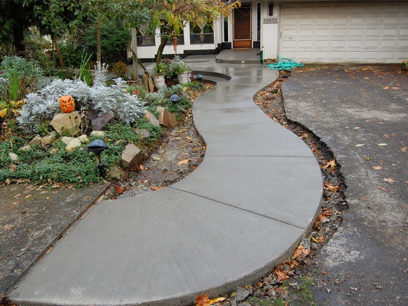 Curved concrete walkway leads to front porch