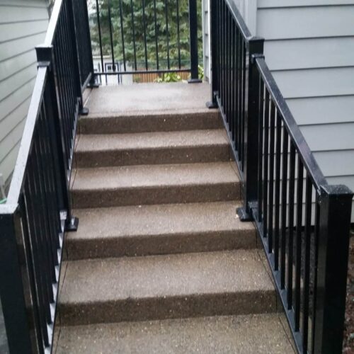 Steps up to a home are flanked by guard handrails