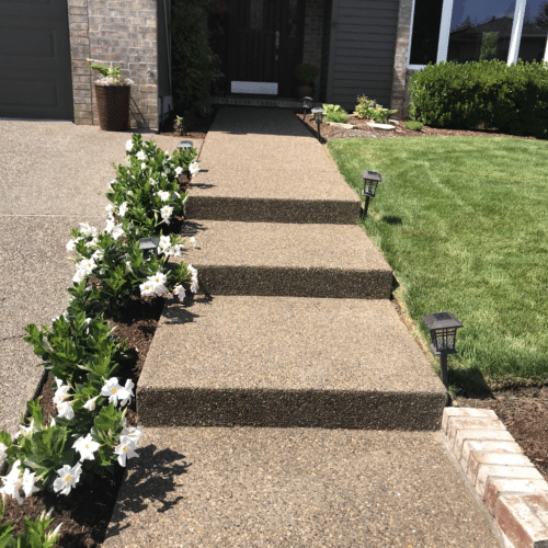 Long step pathway of aggregate concrete steps leading to home entrance