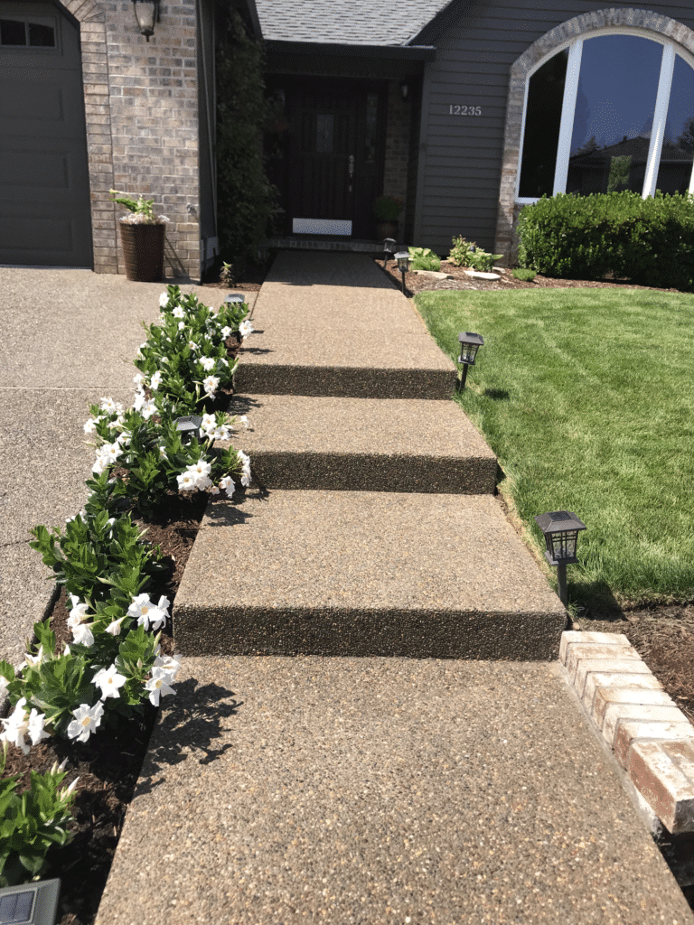 Long step pathway of aggregate concrete steps leading to home entrance