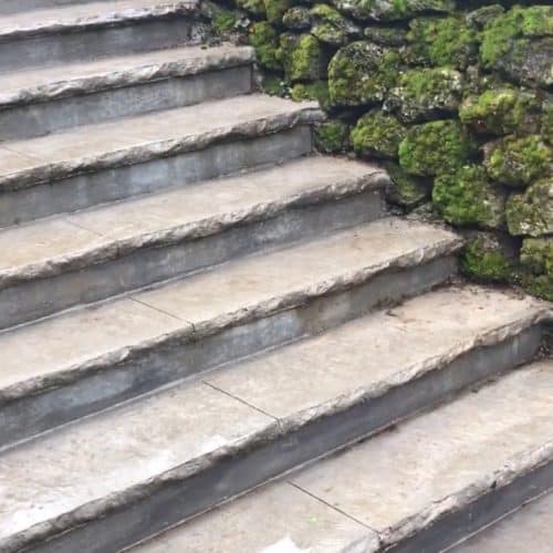 Steps to a home flanked by rock wall