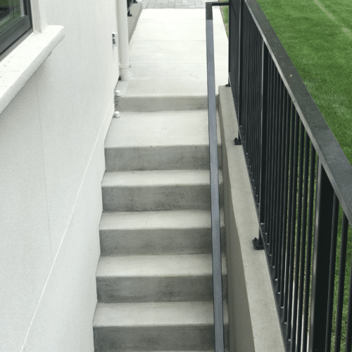 Concrete steps with a retaining wall and handrail