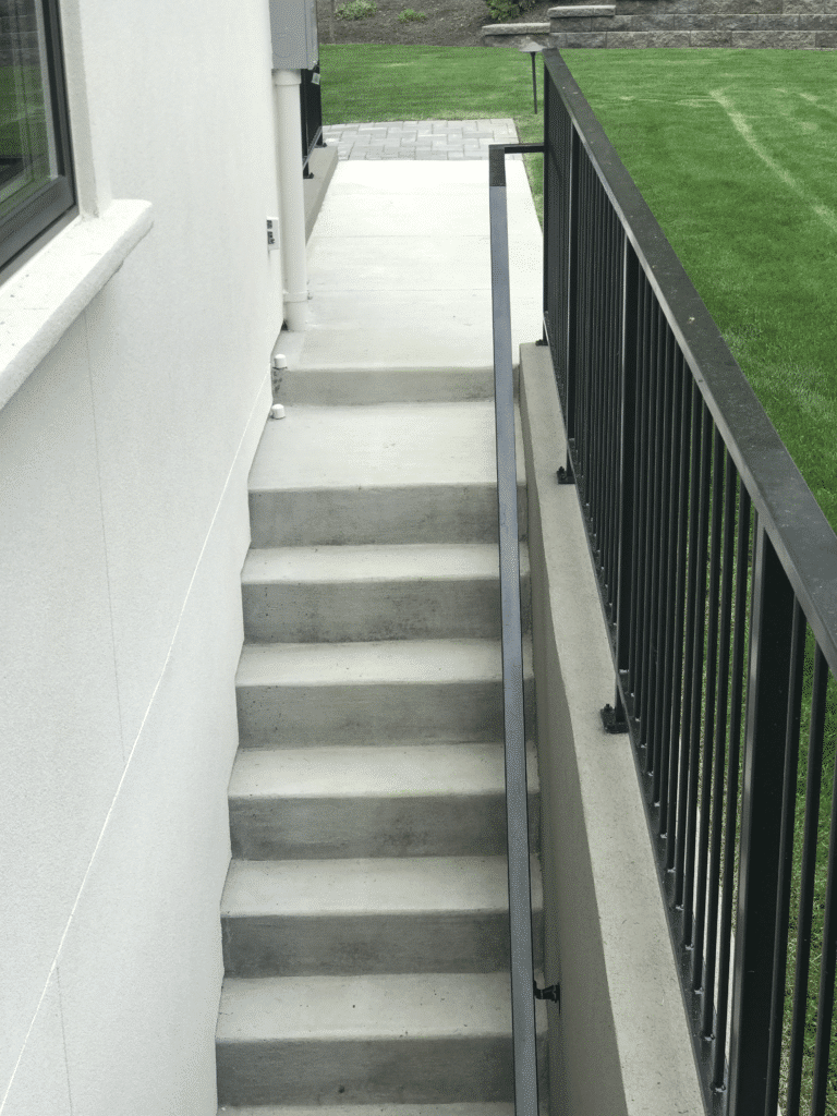 Concrete steps with a retaining wall and handrail