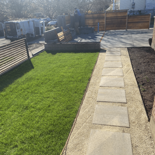 Concrete pad walkway runs beside a residential home