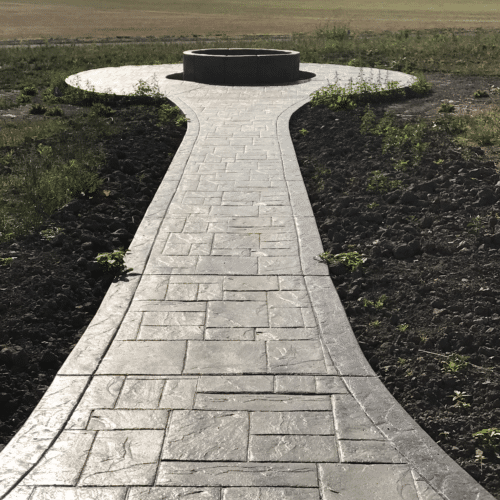 Stamped concrete walkway leads to a planter