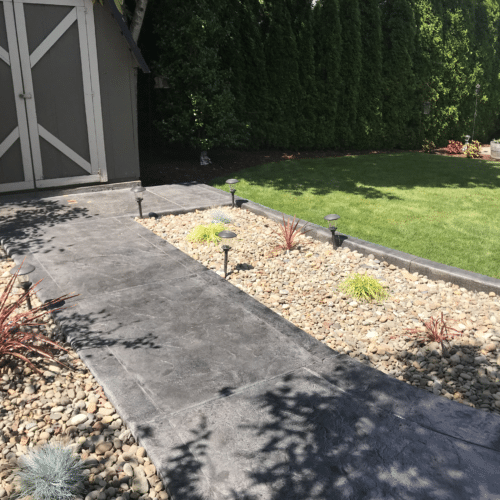 Stamped concrete walkway leads to a shed